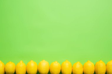 Yeşil arkaplandaki olgun sarı limonların fotokopi alanı ile üst görünümü