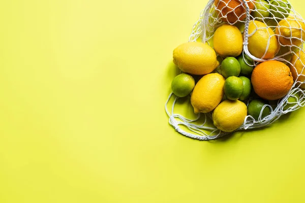 Ovanifrån Mogna Hela Citrusfrukter Sträng Väska Gul Bakgrund — Stockfoto