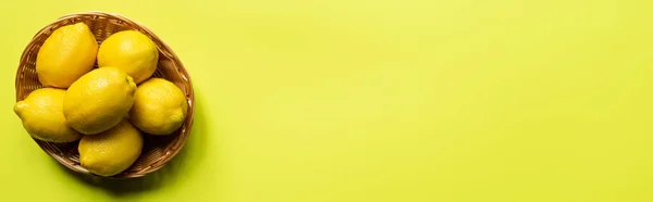 五彩缤纷背景的柳条筐中成熟柠檬的顶部视图 全景作物 — 图库照片