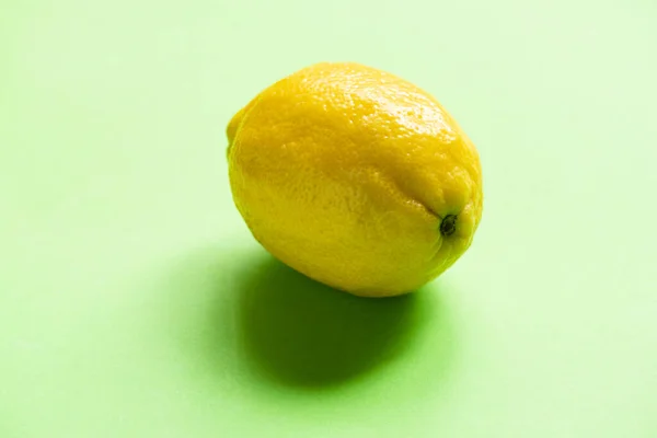 緑の背景にカラフルな熟した黄色のレモン ロイヤリティフリーのストック写真