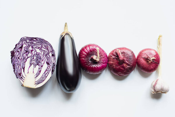 flat lay with red onion, red cabbage, eggplant and garlic on white background