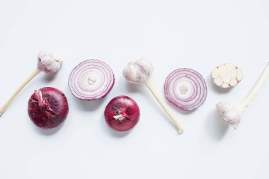 top view of cut and whole red onion and garlic on white background clipart