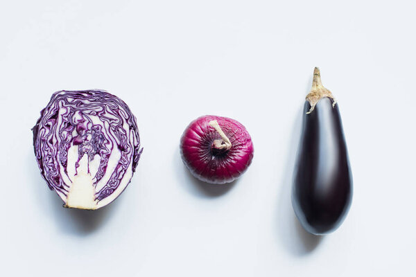 flat lay with red onion, red cabbage, eggplant on white background