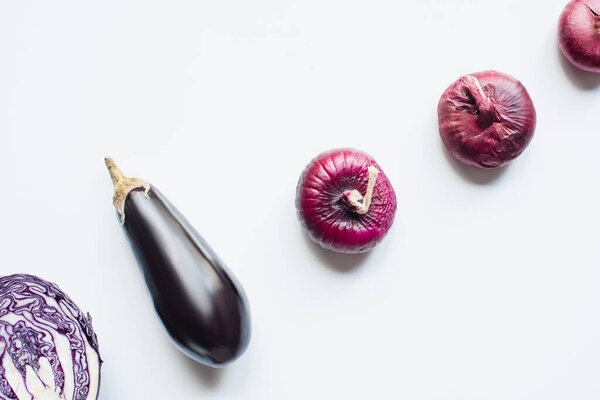flat lay with red onion, red cabbage, eggplant on white background