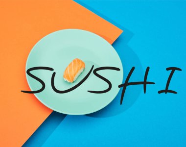 Mavi ve turuncu yüzeyinde suşi harfleri olan taze somon balıklı nigiri.
