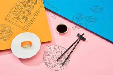 Soya sosu, yemek çubuğu ve mavi, pembe ve turuncu arkaplan üzerine suşi resimli taze nigiri manzarası.