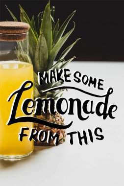 fresh pineapple juice in bottle near delicious fruit and make some lemonade from this lettering on white and black clipart