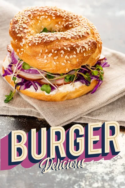 餐巾纸上的新鲜百吉饼靠近汉堡包 在质感表面上刻着美味的字母 — 图库照片