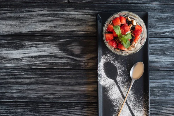 Draufsicht auf leckeres gesundes Dessert mit Früchten und Löffel auf Holztisch — Stockfoto