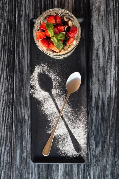 Blick von oben auf süßes, fruchtiges Gourmet-Dessert und Löffel auf Holztisch — Stockfoto