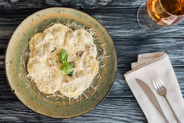 Deliciosos ravioli com espinafre e ricota de queijo, bebida e garfo com faca na mesa de madeira — Fotografia de Stock