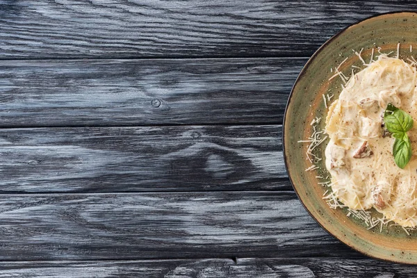 Vista superior de ravioles con espinacas y queso ricotta en plato sobre mesa de madera - foto de stock