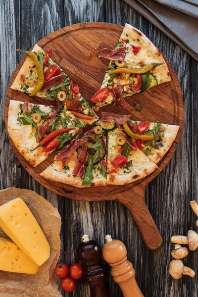 Vista superior de fatias de pizza na placa de corte de madeira — Fotografia de Stock
