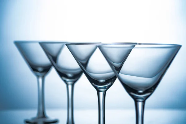 Stillleben mit einer Reihe leerer Martini-Gläser auf grau — Stockfoto