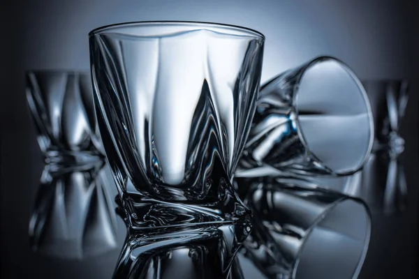 Close up of cognac glasses on grey with reflections — Stock Photo