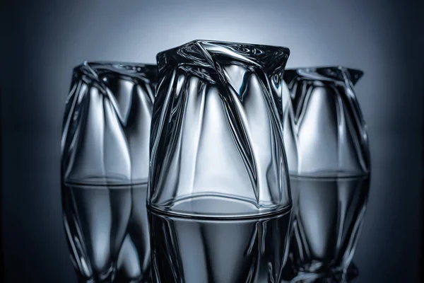 Bicchieri vuoti trasparenti su grigio con riflessi — Foto stock