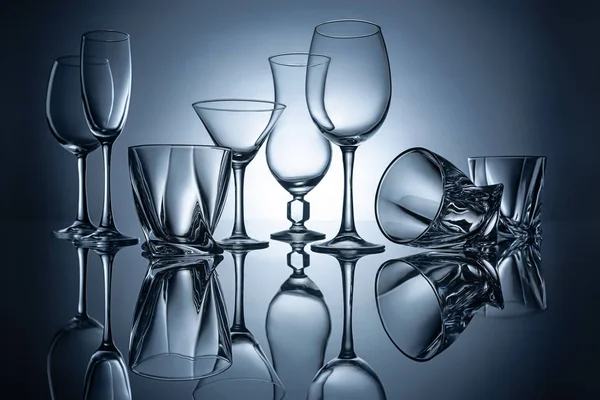 Silhouettes of martini, cognac, champagne and wine empty glasses with reflections — Stock Photo