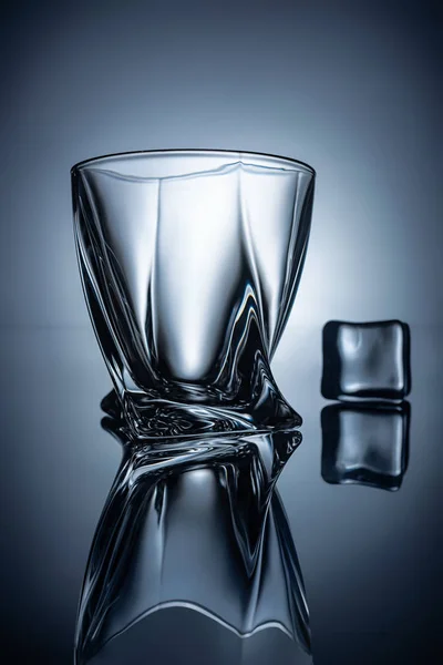 Siluetas de vaso de whisky vacío y cubo de hielo, en gris — Stock Photo