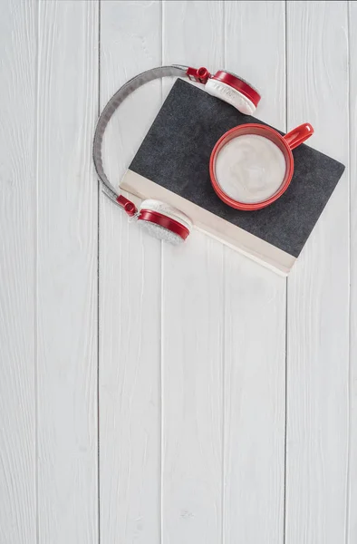 Top view of book, headphones and red cup on white tabletop — Stock Photo