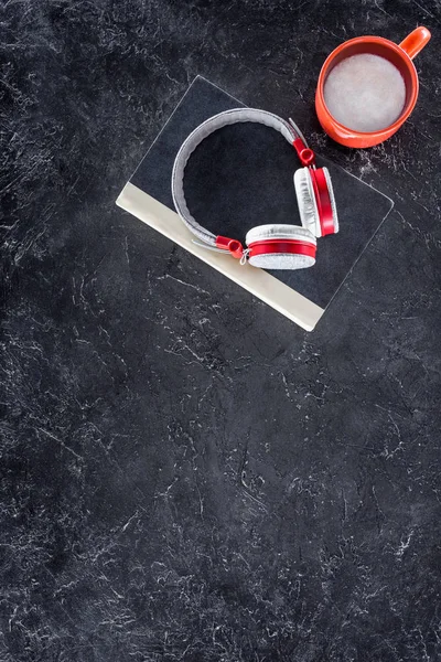 Vue du haut du livre, casque et tasse rouge sur la table grise — Photo de stock