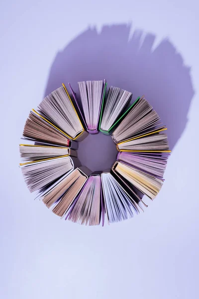 Vista dall'alto di pila di libri in cerchio su tavolo viola — Foto stock