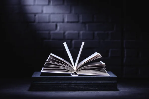 Apri un libro con pagine vuote su un tavolo buio — Foto stock