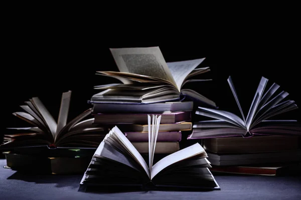 Stack of books on dark surface on black — Stock Photo