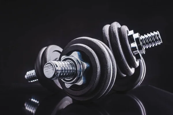 Close-up view of dumbbells and reflection on black, sporting and healthy lifestyle concept — Stock Photo