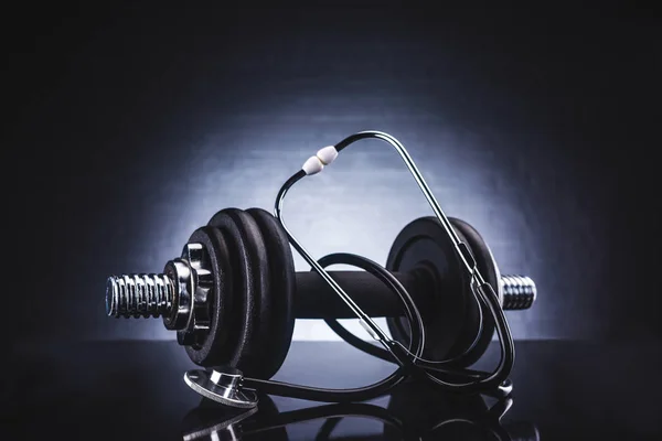 Close-up view of dumbbell and stethoscope, healthy lifestyle concept — Stock Photo