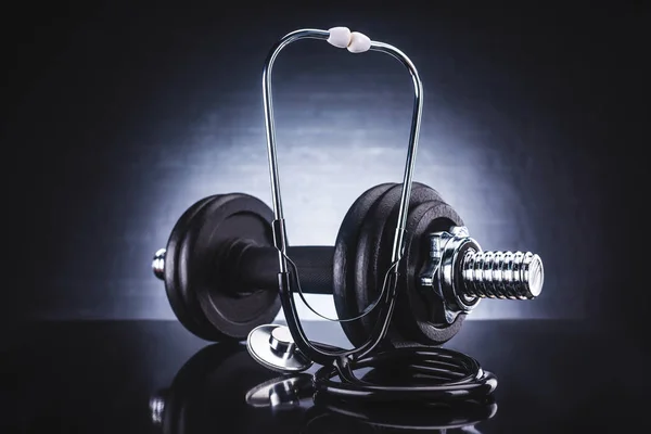 Close-up view of stethoscope and dumbbell, healthy lifestyle concept — Stock Photo