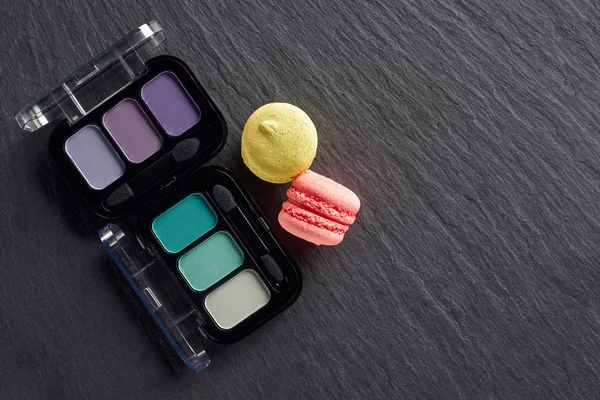 Palettes d'ombres à paupières avec macarons sur fond ardoise foncé — Photo de stock