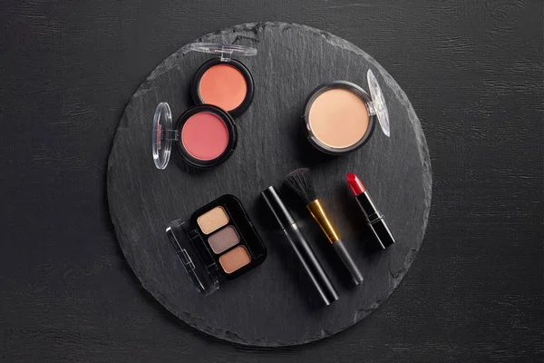 Make-up-Set mit Lidschatten und Rouge auf rundem Schieferhintergrund — Stockfoto