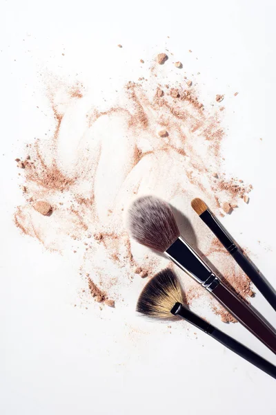 Foundation Schmierereien und Make-up-Pinsel auf weißem Hintergrund — Stockfoto