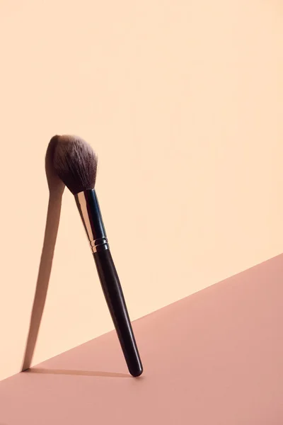 Plush makeup brush on beige background — Stock Photo
