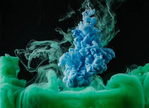 Vista de cerca de la pintura verde y azul abstracta que fluye sobre fondo negro - foto de stock