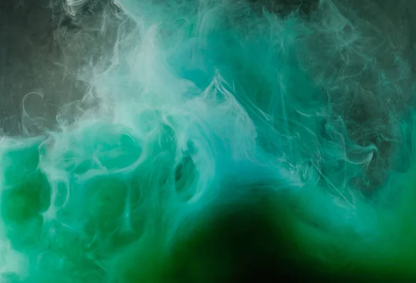 Abstracto fluyendo tinta blanca, verde y azul sobre fondo negro - foto de stock