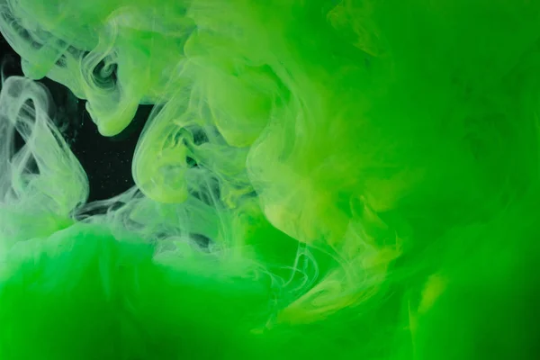 Vista de cerca de la tinta verde brillante abstracta que fluye sobre fondo negro — Stock Photo