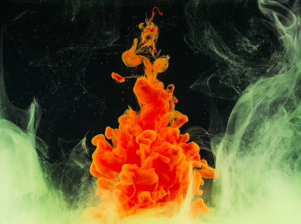 Vista de cerca de brillante explosión de tinta naranja abstracta en negro - foto de stock