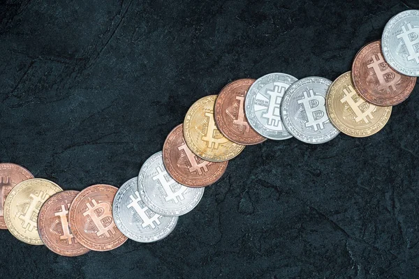 Top view of arranged bitcoins on dark marble tabletop — Stock Photo