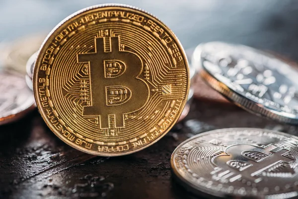 Messa a fuoco selettiva di vari bitcoin su superficie scura — Foto stock