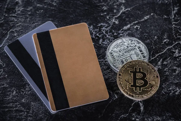 Top view of credit cards and bitcoins on dark marble surface — Stock Photo