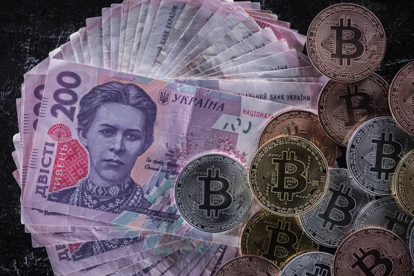 Vista superior de vários bitcoins em notas de hryvnia em mesa de mármore — Fotografia de Stock