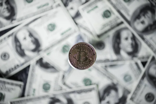 Enfoque selectivo de bitcoin de plata y billetes de dólar en el fondo - foto de stock