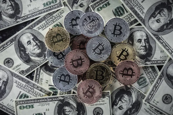 Вид сверху на груду различных биткоинов на банкнотах в долларах — стоковое фото