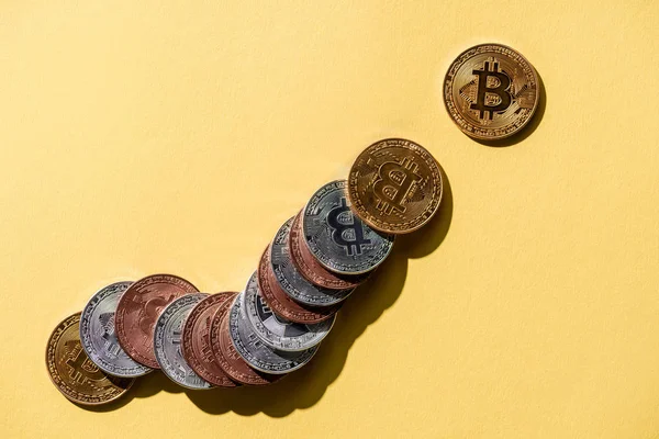 Top view of arranged various bitcoins on yellow tabletop — Stock Photo