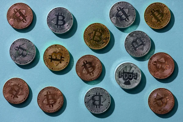 Vista superior de vários bitcoins dispostos em mesa azul — Fotografia de Stock