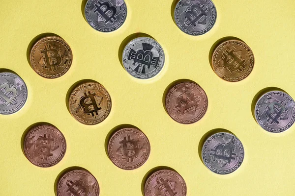 Vue de dessus de divers bitcoins disposés sur plateau jaune — Stock Photo