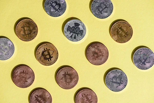 Вид зверху розташовані різні bitcoins на жовтий настільні — стокове фото