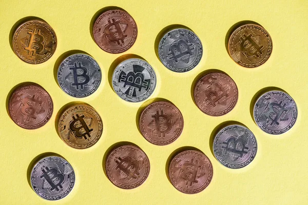 Вид зверху розташовані різні bitcoins на жовтий настільні — стокове фото
