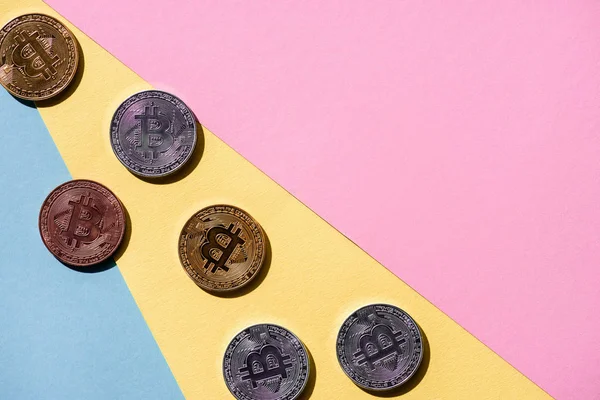 Вид зверху розташовані різні bitcoins на барвистий фон — стокове фото
